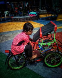 Rear view of woman riding bicycle on street