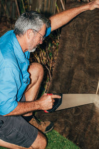 Side view of man cutting wood