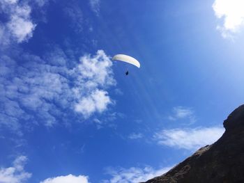 Low angle view of person against blue sky