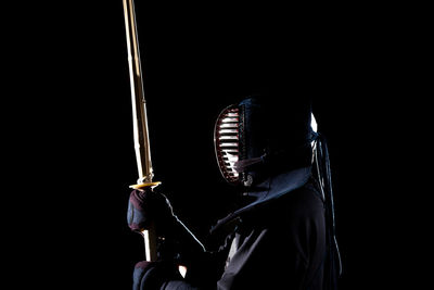 Low angle view of person photographing against black background