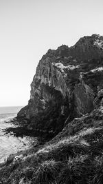 Scenic view of rocks in sea against clear sky