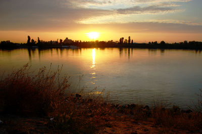 Scenic view of lake against romantic sky at sunset