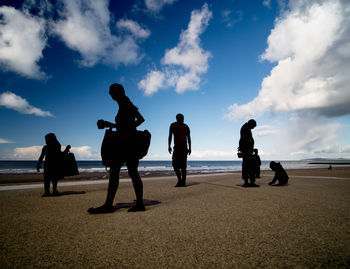 Silhouette people standing on beach