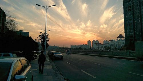 Cars moving on road at sunset