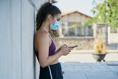 Side view of young woman using mobile phone