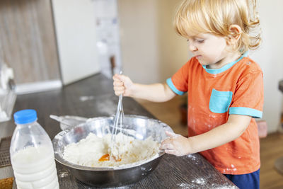 Portrait of cute baby girl preparing food at home