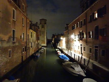 Boats in canal along buildings
