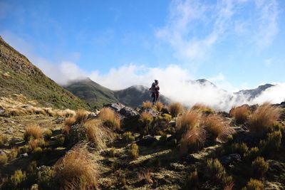 Full length of woman standing on mountain against sky