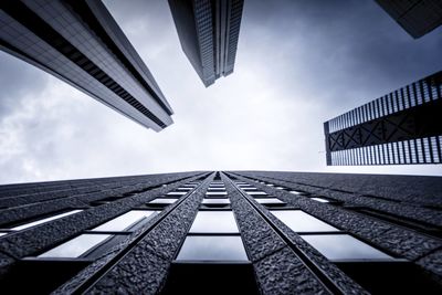 Directly below shot of buildings against sky in city