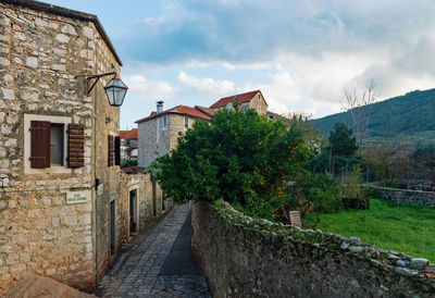 Footpath amidst buildings against sky