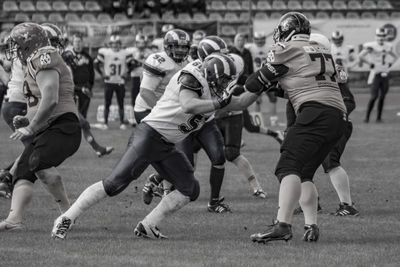 Sportsmen playing american football on field