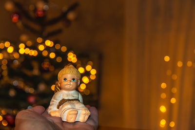 Close-up of figurine with illuminated christmas lights