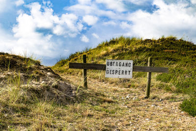 Close-up of information sign against sky