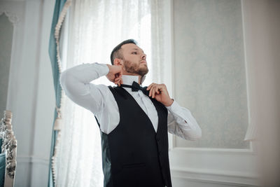 Young man standing by window