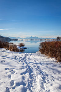 Scenic view of snow covered field against blue sky