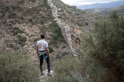 Rear view of man standing on cliff