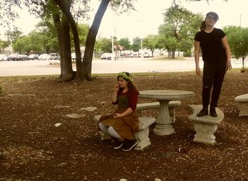 Full length of woman sitting on bench