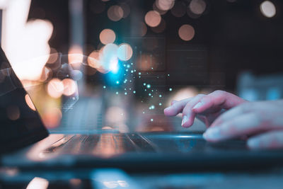 Cropped hand of woman using laptop