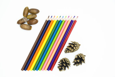 High angle view of multi colored pencils against white background