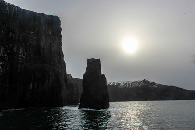 Rock formation in sea against sky