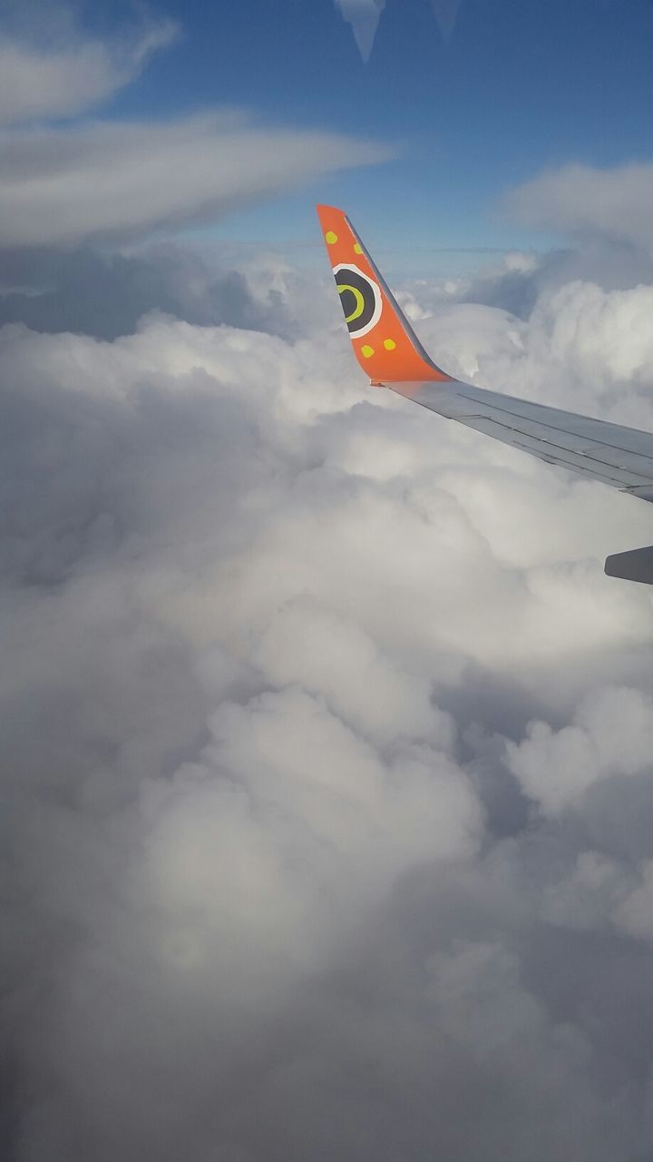 sky, transportation, cloud - sky, flying, cloud, mode of transport, low angle view, mid-air, flag, airplane, scenics, nature, tranquility, cloudy, travel, beauty in nature, journey, outdoors, air vehicle, day