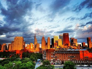 Buildings in city against cloudy sky