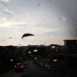 Cars on airplane in city against sky