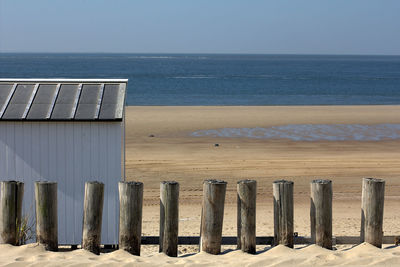 Wooden posts on beach against clear sky