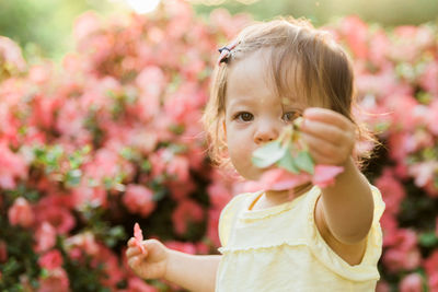 Close-up of girl with flowers against blurred background