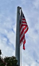 Low angle view of american flag against cloudy sky