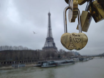 Low angle view of padlocks hanging on river