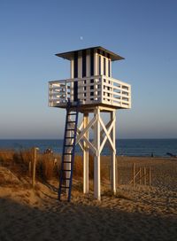 Lifeguard hut on beach against sky