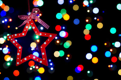 Low angle view of illuminated christmas decorations against sky at night