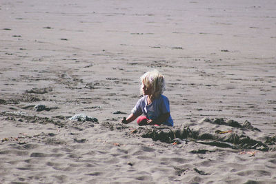Girl sitting on shore at beach