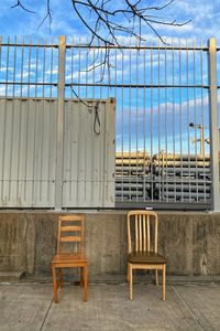 Empty chairs and tables against blue sky