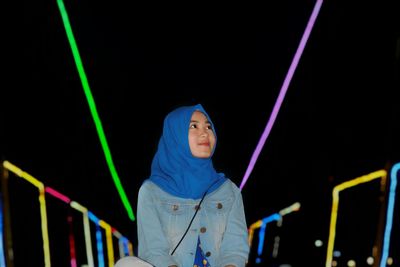 Young woman at amusement park during night