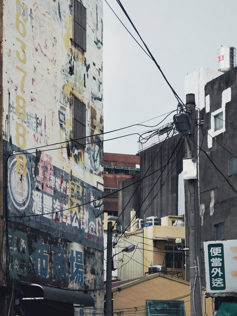 building exterior, built structure, architecture, city, building, cable, residential district, communication, no people, power line, transportation, day, mode of transportation, text, sign, outdoors, electricity, land vehicle, connection, street, power supply, telephone line