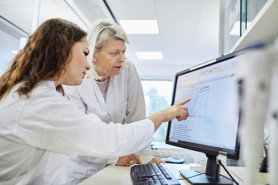 Women analyzing chart on computer screen