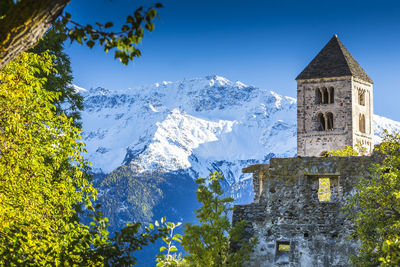 Church by snowcapped mountain against clear sky