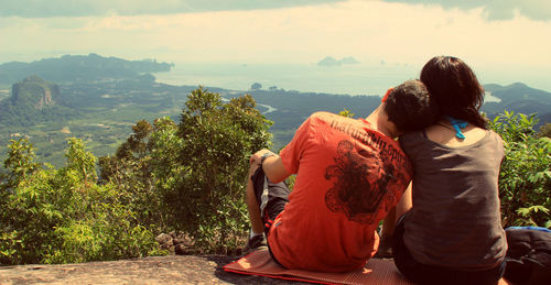 Rear view of couple overlooking countryside landscape