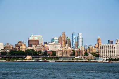 River by buildings against clear sky