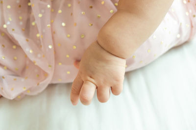 Close-up of baby hand on bed