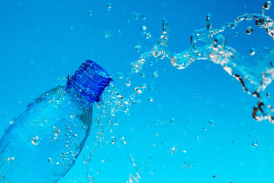 Close-up of water splashing against blue background