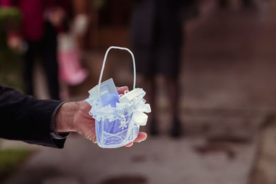 Cropped hand of man holding wedding rings outdoors