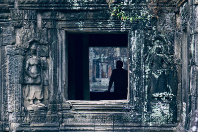 Man seen through old temple window