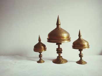 Close-up of lamp on table against wall