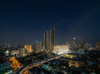 Illuminated cityscape against sky at night