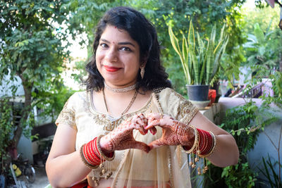 Beautiful woman dressed up indian tradition with henna mehndi design on her hands for karwa chauth