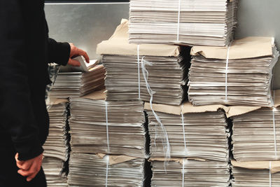 Midsection of man holding stacked paper