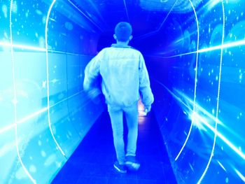 Rear view of man walking in aquarium